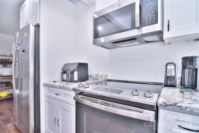 kitchen with dark wood-type flooring, stainless steel appliances, and white cabinets