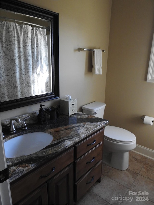 bathroom with vanity, toilet, and tile patterned flooring