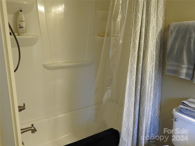 bathroom with shower / tub combo and toilet