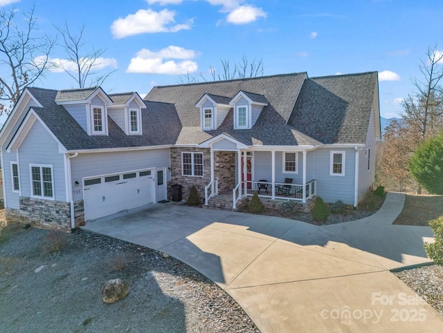 new england style home with a garage and covered porch