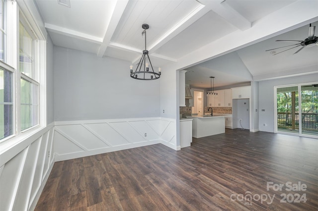 interior space featuring dark hardwood / wood-style floors, beamed ceiling, and ceiling fan with notable chandelier