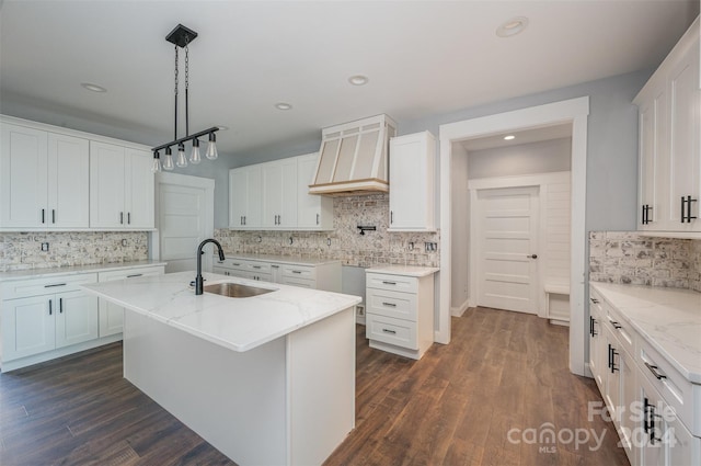 kitchen featuring sink, white cabinets, a kitchen island with sink, and dark hardwood / wood-style floors