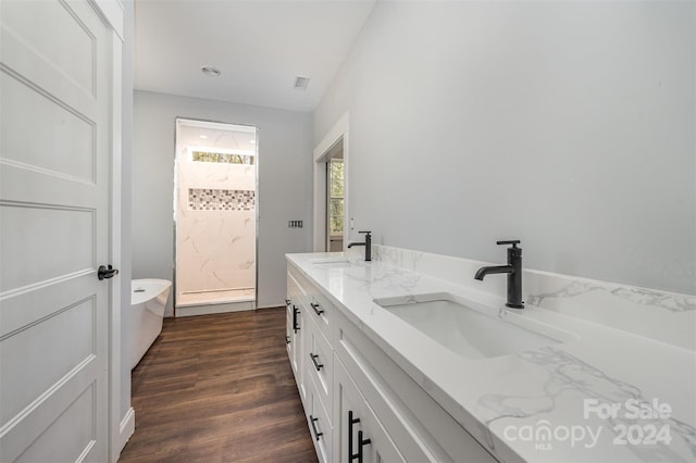 bathroom with vanity, hardwood / wood-style floors, and a bathtub