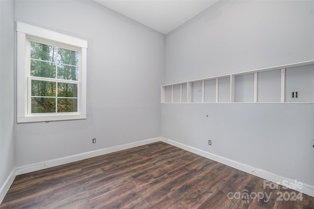 empty room with vaulted ceiling and dark hardwood / wood-style floors