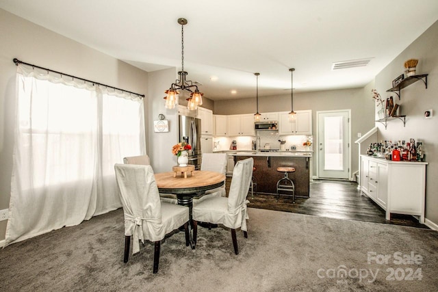 dining space featuring a notable chandelier and dark hardwood / wood-style flooring