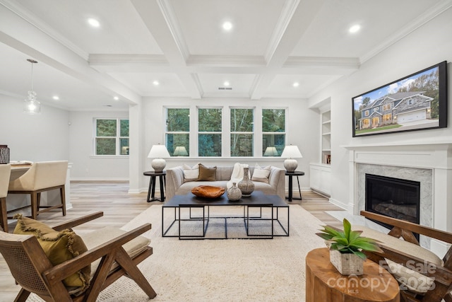 living room featuring a high end fireplace, built in shelves, coffered ceiling, light hardwood / wood-style floors, and beamed ceiling