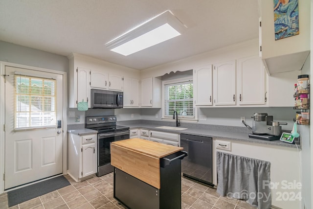 kitchen featuring white cabinets, black dishwasher, sink, and range with electric cooktop