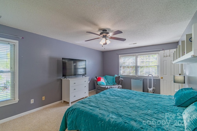 bedroom with a textured ceiling, multiple windows, and ceiling fan