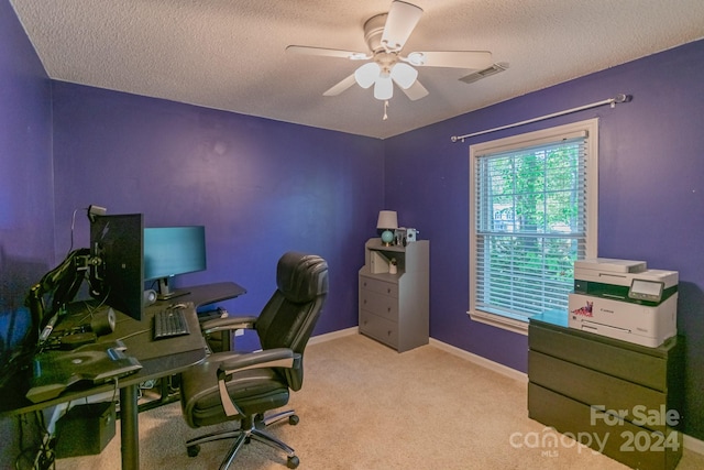 office featuring ceiling fan, light colored carpet, and a textured ceiling