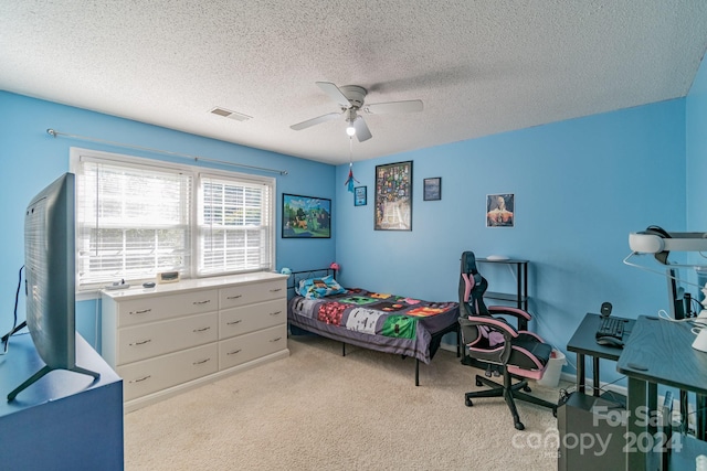 carpeted bedroom featuring ceiling fan and a textured ceiling