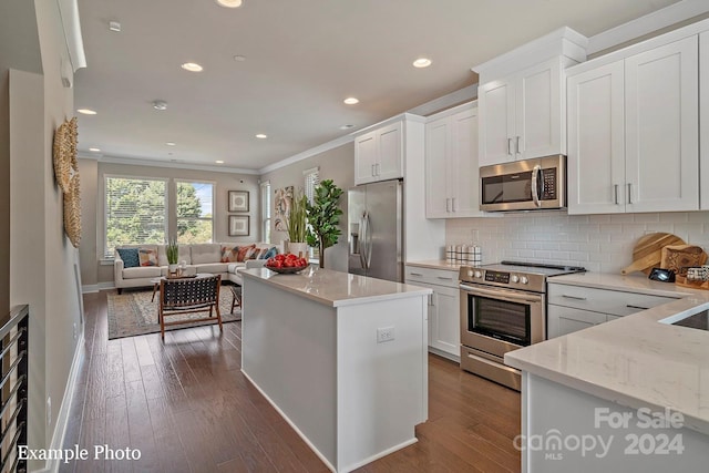 kitchen with stainless steel appliances, ornamental molding, backsplash, open floor plan, and white cabinets