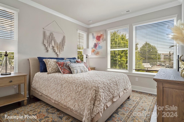 bedroom with baseboards, multiple windows, ornamental molding, and visible vents
