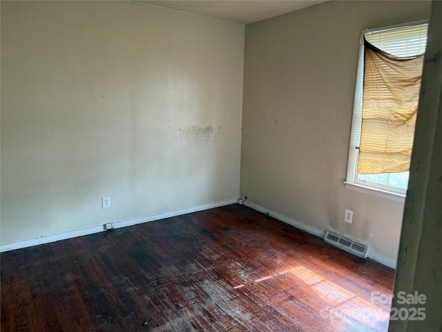 spare room featuring visible vents, baseboards, and hardwood / wood-style flooring