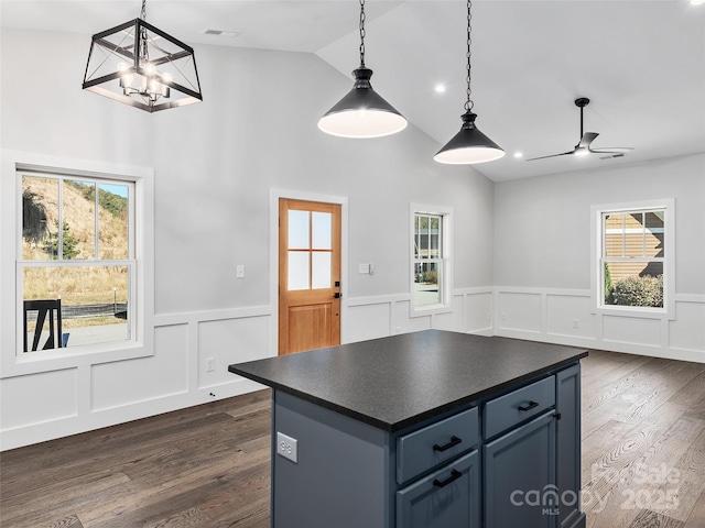 kitchen with vaulted ceiling, a wealth of natural light, blue cabinetry, and decorative light fixtures