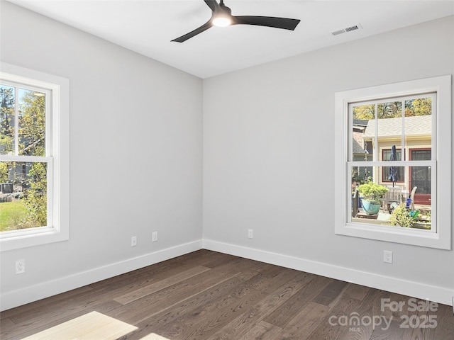 unfurnished room featuring a wealth of natural light, dark wood-type flooring, and ceiling fan