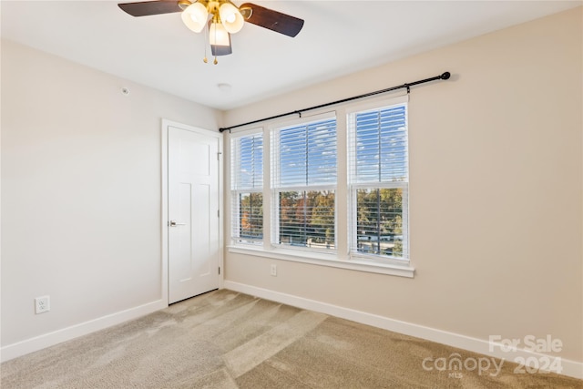 carpeted spare room featuring ceiling fan