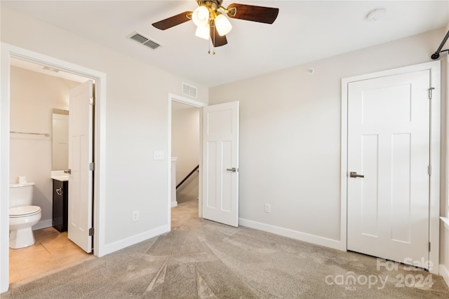 unfurnished bedroom with light colored carpet, ceiling fan, and ensuite bath