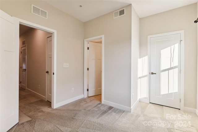 unfurnished bedroom featuring light colored carpet and a closet