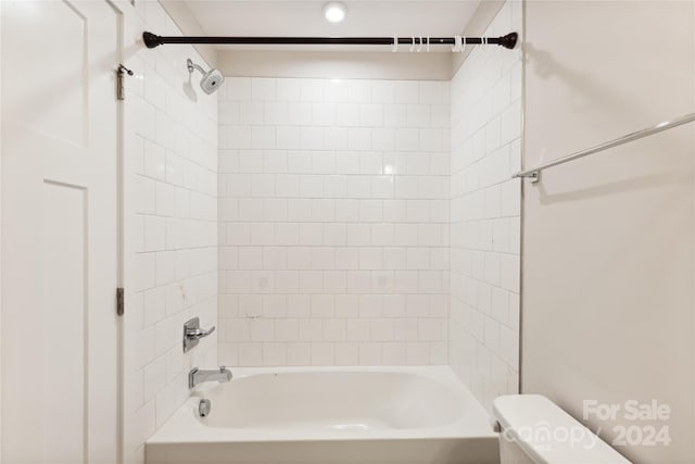 bathroom featuring tiled shower / bath and toilet