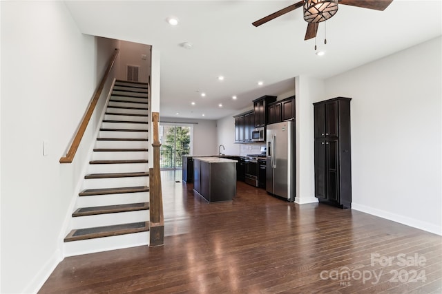 stairs featuring wood-type flooring, ceiling fan, and sink