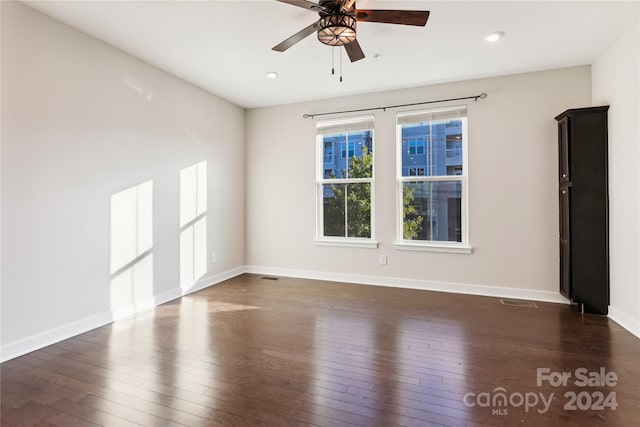 empty room with ceiling fan and dark hardwood / wood-style floors