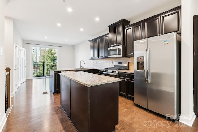 kitchen featuring kitchen peninsula, sink, light wood-type flooring, and appliances with stainless steel finishes