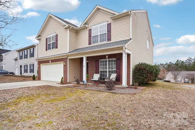 view of front of property with a garage, covered porch, and a front lawn