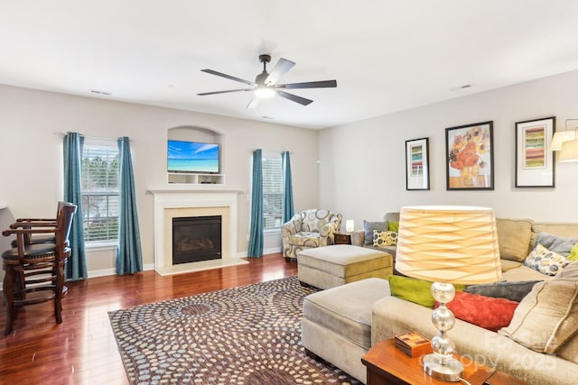 living room featuring ceiling fan and dark hardwood / wood-style floors