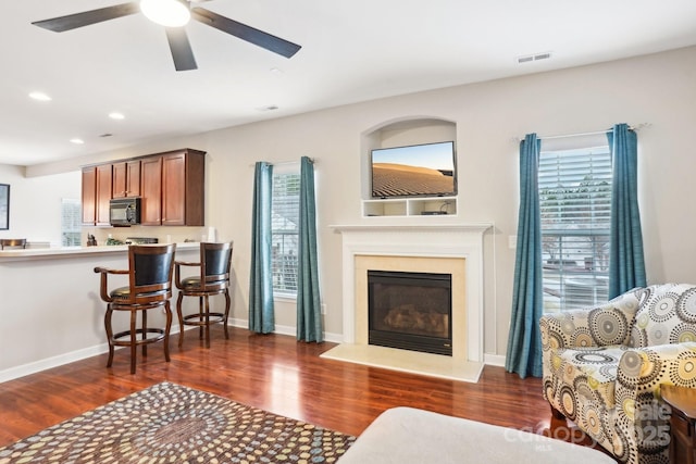 living room with dark wood-type flooring and ceiling fan