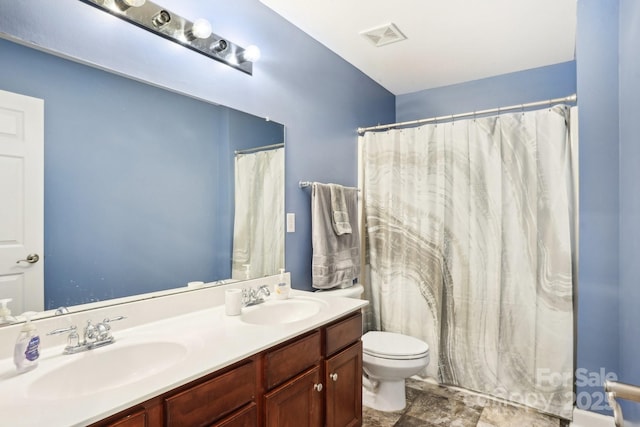 bathroom featuring toilet, vanity, and a shower with shower curtain