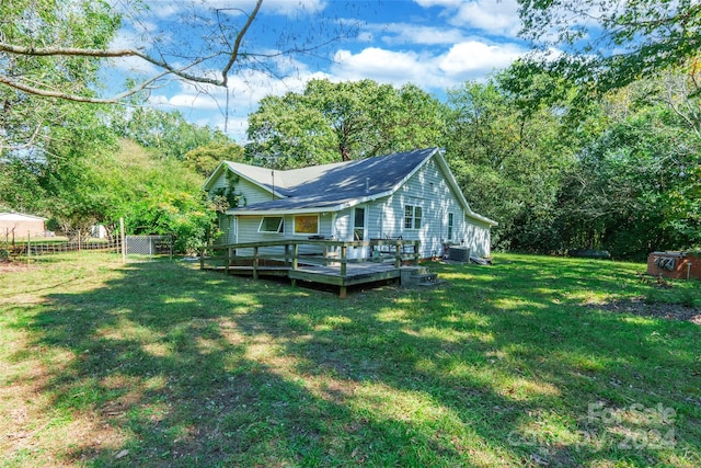 back of house with a yard, a deck, and central air condition unit