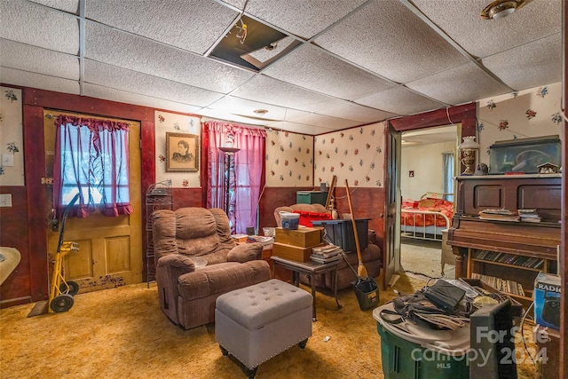 sitting room with a drop ceiling and carpet