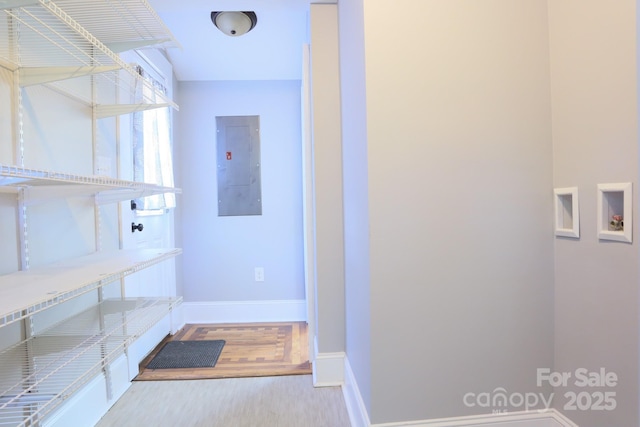 interior space with light hardwood / wood-style floors, electric dryer hookup, washer hookup, and electric panel