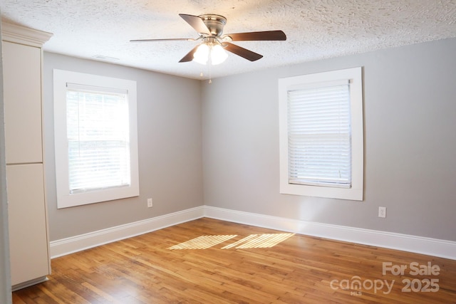 spare room with a textured ceiling, ceiling fan, and hardwood / wood-style flooring