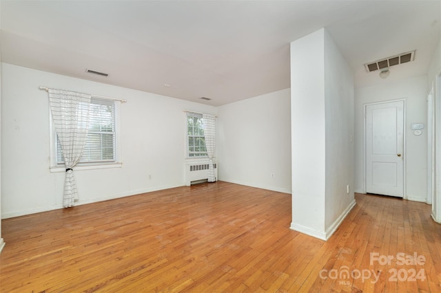 spare room with plenty of natural light, light hardwood / wood-style flooring, and radiator