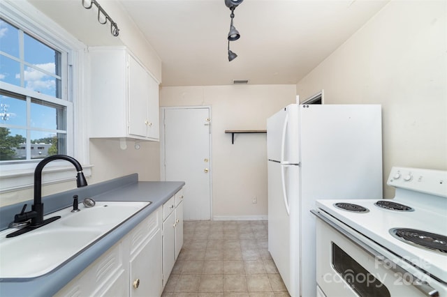 kitchen featuring white appliances, white cabinetry, and sink