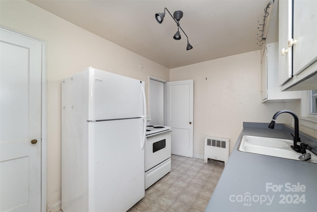 kitchen featuring white appliances, white cabinets, sink, and radiator