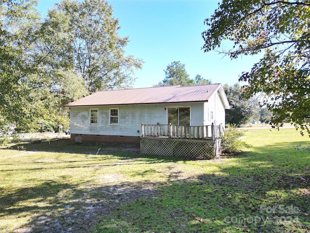 view of front of home with crawl space, a wooden deck, a front lawn, and metal roof