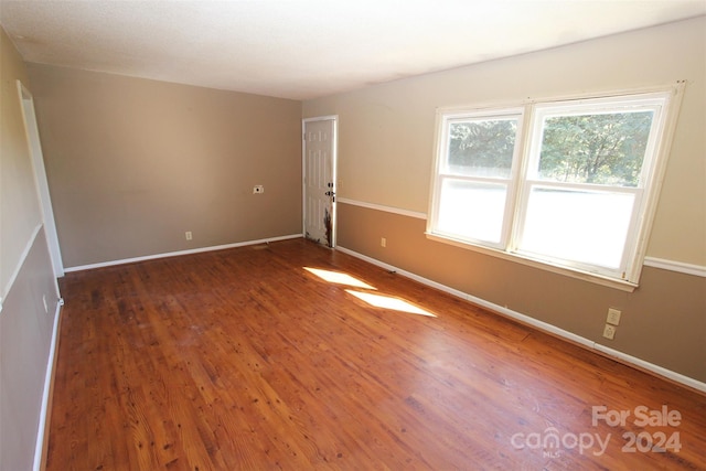 unfurnished room with wood finished floors and baseboards