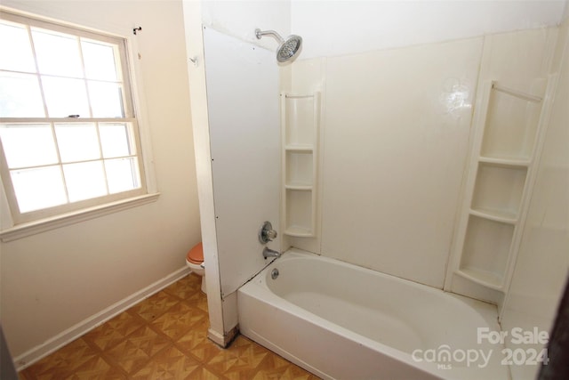 bathroom with toilet, parquet floors, and tub / shower combination