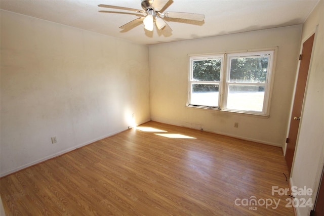 unfurnished room with light wood-type flooring, ceiling fan, and baseboards