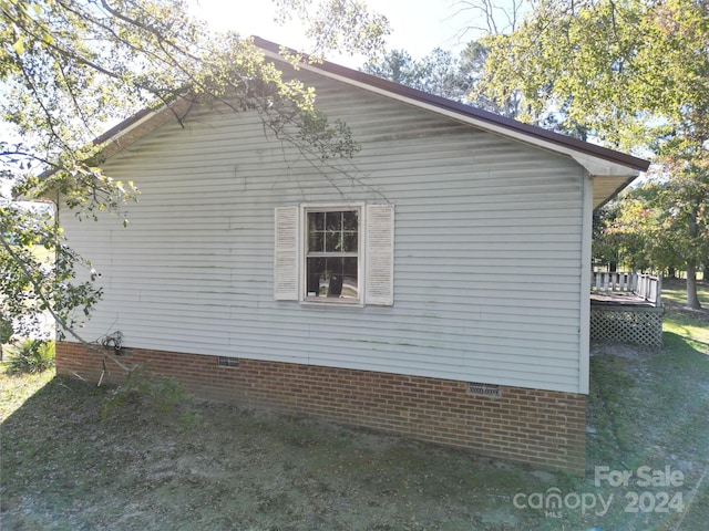 view of property exterior featuring crawl space and a wooden deck
