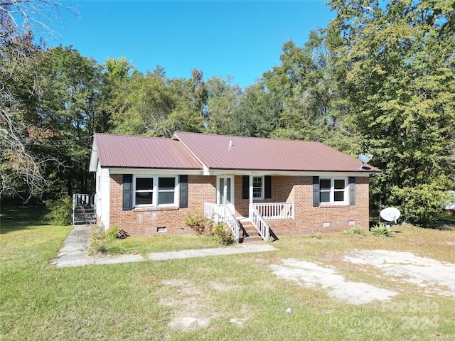 ranch-style house featuring brick siding, a front yard, crawl space, metal roof, and a porch