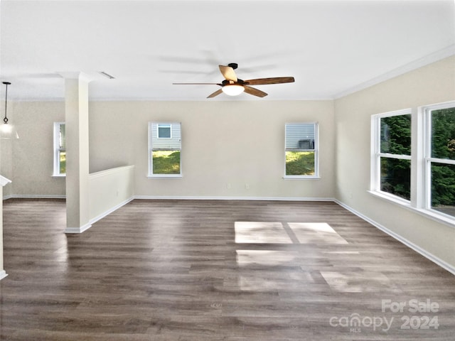 spare room with ornamental molding, dark wood-type flooring, ceiling fan, and plenty of natural light