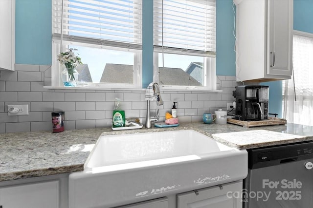 kitchen with white cabinetry, a healthy amount of sunlight, stainless steel dishwasher, and sink