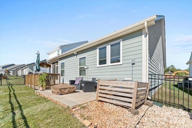 rear view of property featuring a lawn and a patio