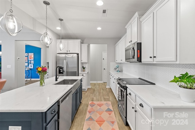 kitchen featuring white cabinetry, stainless steel appliances, decorative light fixtures, and light wood-type flooring