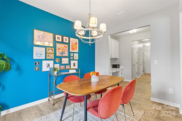 dining area featuring light hardwood / wood-style floors and a chandelier