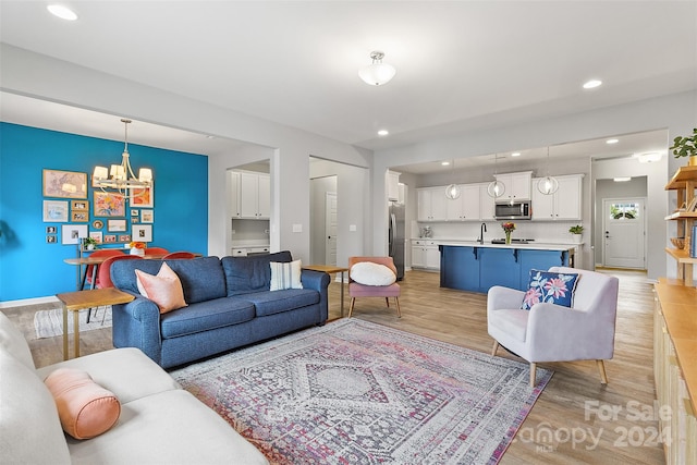 living room with a notable chandelier and light hardwood / wood-style floors