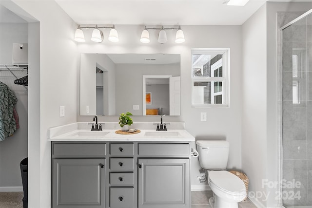 bathroom featuring a shower with door, vanity, toilet, and tile patterned floors